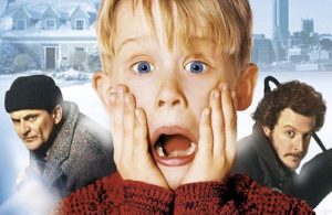 Das Plakat zum beliebten Weihnachtsfilm Kevin allein zu Haus. Kevin steht im Vordergrund und schaut verängstigt mit offenem Mund, hinter ihm sind zwei Einbrecher.