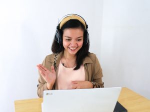 Ein Mädchen ist in einem Online-Meeting und lacht