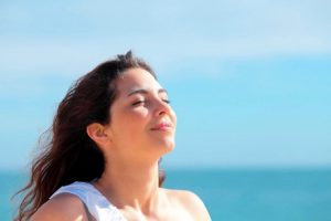 Eine junge Frau atmet frische Luft ein und sieht entspannt aus
